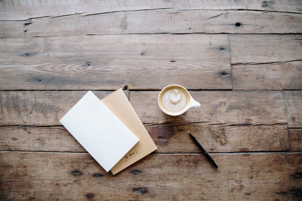 cropped-coffee-and-notepad-on-wooden-table.jpg
